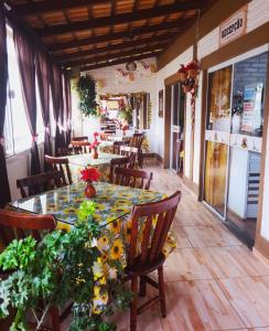 un restaurante con una mesa y sillas con flores. en Pousada Alegria do Cowboy, en Penha