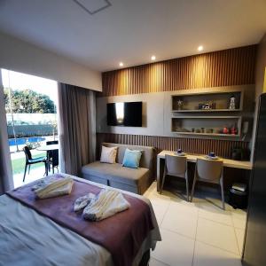 um quarto com uma cama, uma secretária e uma mesa em Mana Beach Experience Muro Alto 13 C Térreo em Porto de Galinhas