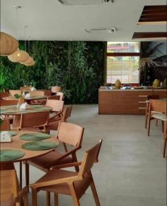 une salle à manger avec des tables et des chaises en bois dans l'établissement Mana Beach Experience Muro Alto 13 C Térreo, à Porto de Galinhas