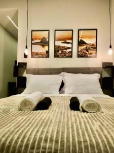 a bedroom with a bed with four pictures on the wall at Apartamento 1 quarto em Copacabana in Rio de Janeiro