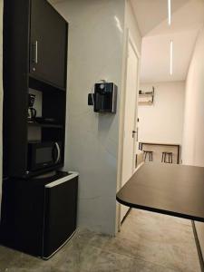 a kitchen with a table and a tv on a wall at Apartamento 1 quarto em Copacabana in Rio de Janeiro