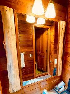 uma casa de banho com um espelho numa cabina de madeira em Patagonia Home em Shimoda