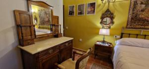 um quarto com uma cama e uma cómoda com um espelho em Cortijo Rodeo. Alojamiento Rural em Carcabuey