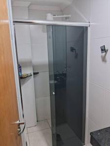 a shower stall with a glass door in a bathroom at Apartamento perto da praia com ar condicionado in Praia Grande