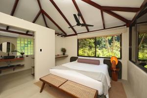 a bedroom with a bed and a large window at SCP Corcovado Wilderness Lodge in San Pedrillo