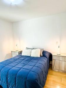 メンドーサにあるCasa Huesped VIII Edificio premium en excelente zonaの白い部屋の大きな青いベッド1台(テーブル2台付)