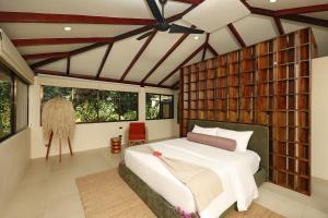a bedroom with a large bed in a room with windows at SCP Corcovado Wilderness Lodge in San Pedrillo