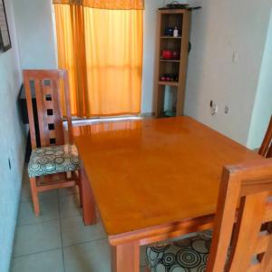 a wooden dining room table with two chairs and a window at casa sola dos niveles in Chalco de Díaz Covarrubias