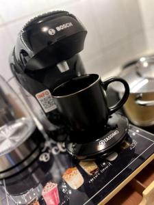 eine schwarze Kaffeetasse auf einer Theke in der Unterkunft Penthouse, Sonnenbalkon, Netflix in Saarbrücken