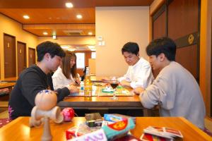 um grupo de pessoas sentadas à mesa a comer em COGO Ryogoku em Tóquio