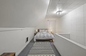 a bedroom with a bed in a white room at Housepitality - City View Loft - German Village in Columbus