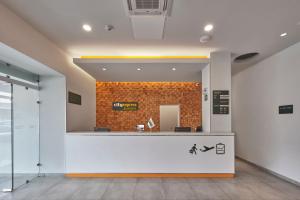 a lobby with a reception desk and a brick wall at City Express Junior by Marriott CDMX Sullivan in Mexico City