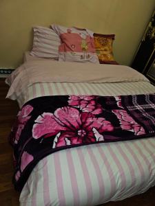 a bed with a pink flower blanket on it at Ina-Olivia F5 à Massy in Massy