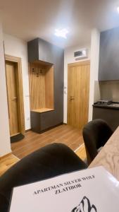 兹拉蒂博尔Silver Wolf SPA & relax的带厨房的房间和带桌子的房间