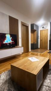 兹拉蒂博尔Silver Wolf SPA & relax的带电视和咖啡桌的客厅