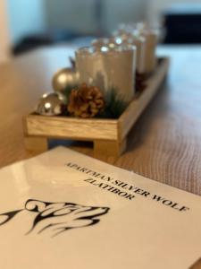兹拉蒂博尔Silver Wolf SPA & relax的一张桌子,上面放着蜡烛和圣诞装饰 更多13张照片