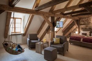 a bedroom with a bed and two chairs and a swing at Hollerhöfe - Zu Gast im Dorf in Kemnath