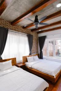 1 dormitorio con 2 camas y ventilador de techo en Đại Nam Villa en Buon Ma Thuot