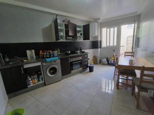 een keuken met een wasmachine en een tafel. bij Casablanca Geusthouse in Casablanca