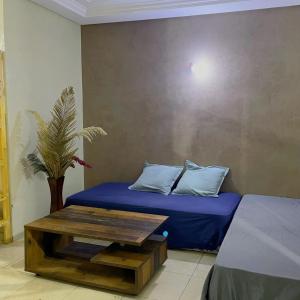 Cette chambre comprend un lit et une table avec des oreillers. dans l'établissement Casablanca Geusthouse, à Casablanca