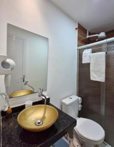 a bathroom with a gold sink and a toilet at MSFlats Paripueira Praia Wifi Ar Cozinha e Varanda Nascente c Rede in Paripueira