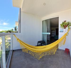 a hammock on the balcony of a house at MSFlats Paripueira Aconchegante, Moderno Praia Mansa in Paripueira