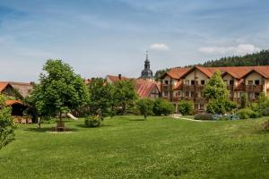 un gran edificio con un césped verde delante de él en Hollerhöfe - Zu Gast im Dorf, en Kemnath