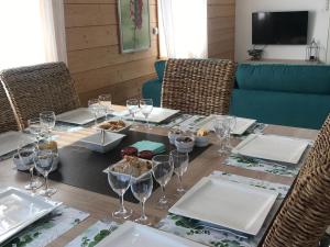 a table with wine glasses and food on it at Maison lumineuse avec sauna, terrasse sud, proche Gérardmer, animaux acceptés - FR-1-589-369 in Gérardmer
