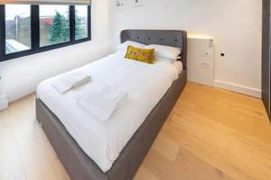 a large bed in a room with at Modern and Bright Ealing Common Duplex in London