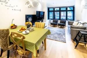 a living room with a table and a couch at Modern and Bright Ealing Common Duplex in London