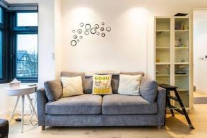 un soggiorno con divano blu in una camera di Modern and Bright Ealing Common Duplex a Londra