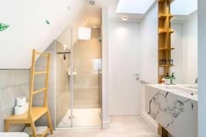 a bathroom with a shower and a sink and a ladder at Modern and Bright Ealing Common Duplex in London