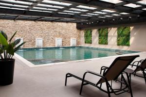 a swimming pool with two chairs and a table at Gramado Parks in Gramado