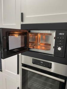 Un horno microondas con la puerta abierta en una cocina. en Stadtnah & Chic - Ihringshausen Retreat, en Fuldatal