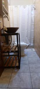a bathroom with a toilet and a white shower curtain at A&F 4 Habitación con baño privado in San Fernando del Valle de Catamarca