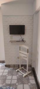 a room with a tv on a brick wall at SUITE A&F Habitación con baño privado in San Fernando del Valle de Catamarca