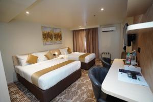 a hotel room with two beds and a desk at Dê MOCCIS Boutique Hotel in Kuala Lumpur