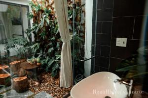 a bathroom with a shower with plants and a sink at ngaunhien's house - Homestay in Thôn Dư Khánh