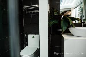 a bathroom with a white toilet and a sink at ngaunhien's house - Homestay in Thôn Dư Khánh