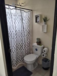 a bathroom with a toilet and a shower curtain at Villa jr 4 by Villas Oasis Guacalillo in Tárcoles