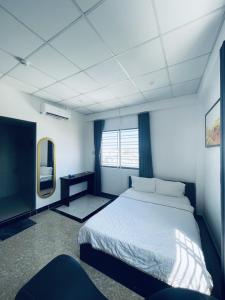 - une chambre avec un lit blanc et un miroir dans l'établissement T ONE II HOSTEL, à Cần Thơ