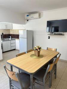 a kitchen with a wooden table with a vase of flowers on it at Complejo Sucre I in San Luis