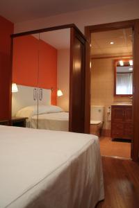 タレガにあるApartaments Tarrega Lagranjaのベッドルーム1室(ベッド1台付)、バスルーム(バスタブ付)が備わります。