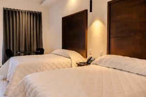 um quarto de hotel com duas camas e uma janela em Hotel Gran Avenida, Navojoa em Navojoa