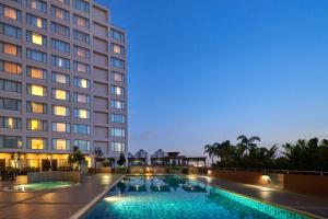 a hotel with a swimming pool in front of a building at Renaissance Johor Bahru Hotel in Johor Bahru