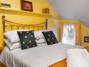 een slaapkamer met een bed met zwart-witte kussens bij Smugglers Cottage in New Milton