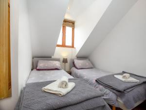 two twin beds in a room with towels on them at Candles Cottage in Cubert