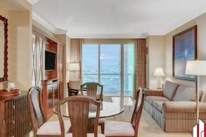 a living room with a couch and a table with chairs at MGM Signature-07-802 1Br 2Ba Balcony Suite in Las Vegas