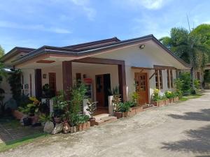 a small house with a lot of plants at Baywalk Garden Pension House in Masbate