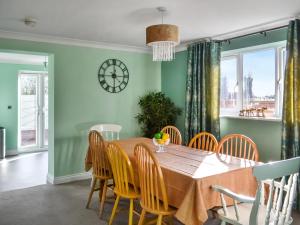 a dining room with a table and chairs and a clock at Pondside in Boston